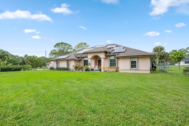 view of front facade with a front yard and solar panels