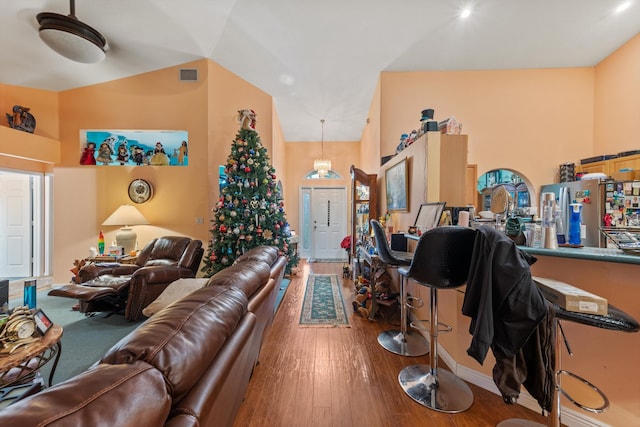 living room featuring wood-type flooring and vaulted ceiling