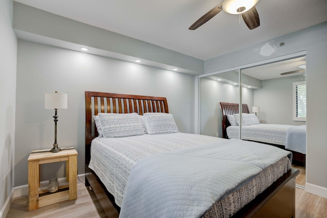 bedroom with a closet, light wood-type flooring, and ceiling fan