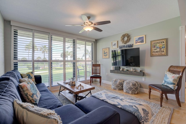 living room featuring ceiling fan and a textured ceiling