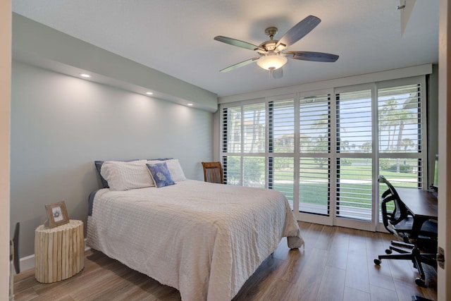 bedroom featuring multiple windows, access to outside, ceiling fan, and hardwood / wood-style flooring