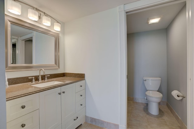 bathroom featuring tile patterned flooring, vanity, and toilet