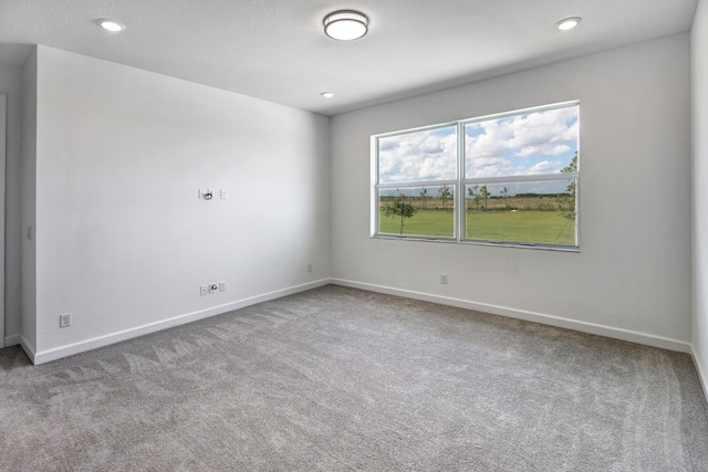 carpeted spare room featuring a textured ceiling