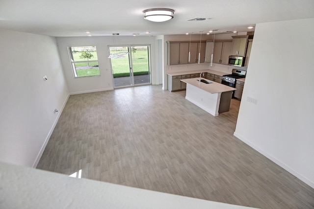 kitchen featuring appliances with stainless steel finishes, light wood-type flooring, and a center island