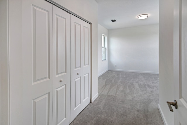 hall with light colored carpet