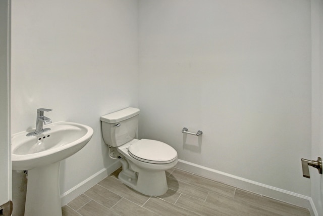 bathroom with hardwood / wood-style floors and toilet