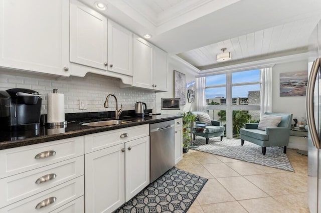 kitchen with crown molding, white cabinets, stainless steel dishwasher, and sink