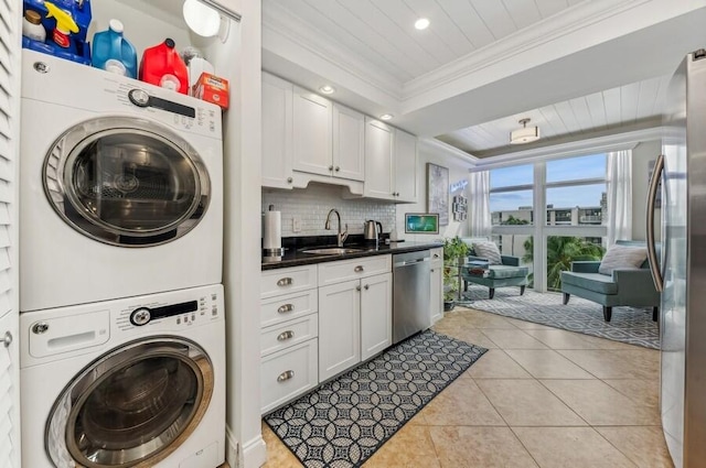 washroom featuring sink, crown molding, stacked washer and clothes dryer, and light tile patterned floors