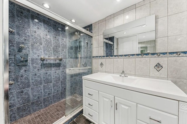 bathroom with vanity, walk in shower, and tile walls