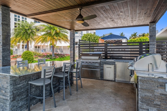 view of patio / terrace featuring a gazebo, grilling area, ceiling fan, area for grilling, and exterior bar