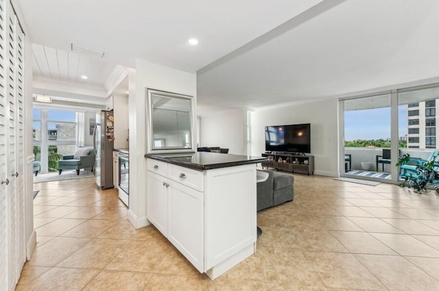 kitchen with crown molding, light tile patterned floors, plenty of natural light, and white cabinets