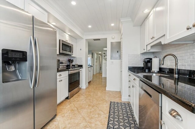 kitchen with tasteful backsplash, appliances with stainless steel finishes, sink, and white cabinets