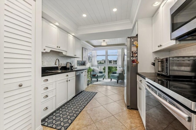 kitchen with sink, appliances with stainless steel finishes, white cabinetry, and tasteful backsplash