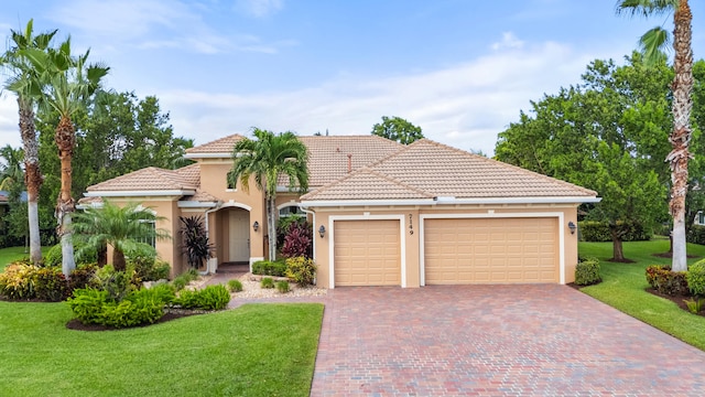 mediterranean / spanish home featuring a garage and a front lawn