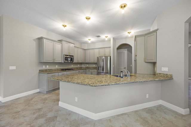 kitchen featuring gray cabinets, sink, kitchen peninsula, appliances with stainless steel finishes, and a textured ceiling