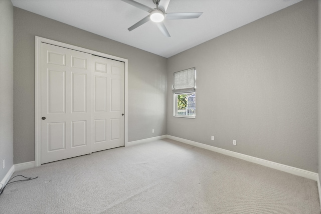 unfurnished bedroom featuring ceiling fan, a closet, and carpet flooring