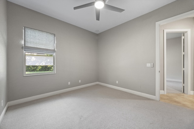 spare room with ceiling fan and light colored carpet