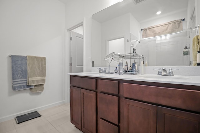 bathroom featuring vanity, a tile shower, and tile patterned floors