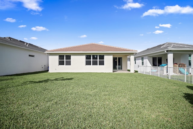 rear view of property featuring a lawn