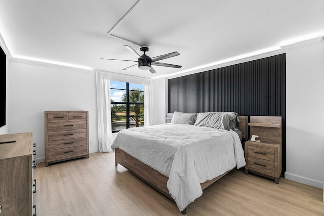 bedroom featuring light hardwood / wood-style floors, ceiling fan, and crown molding