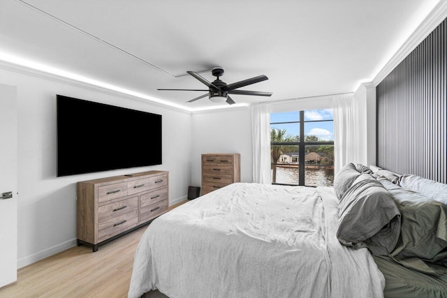 bedroom with crown molding, light hardwood / wood-style floors, and ceiling fan