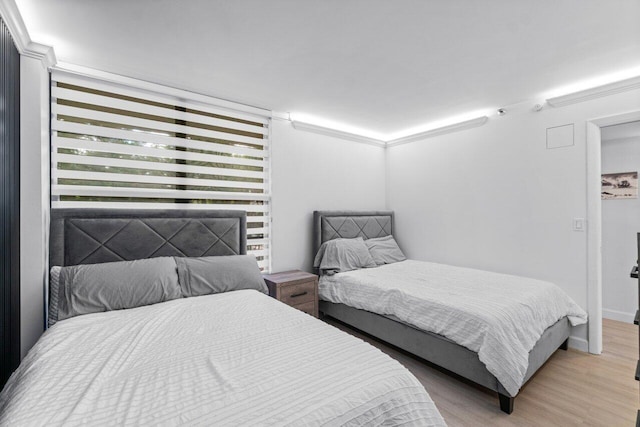 bedroom featuring light hardwood / wood-style floors and ornamental molding