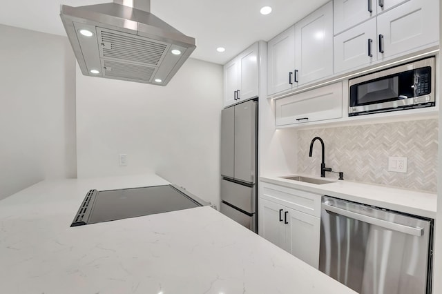 kitchen with white cabinetry, light stone counters, stainless steel appliances, island exhaust hood, and sink