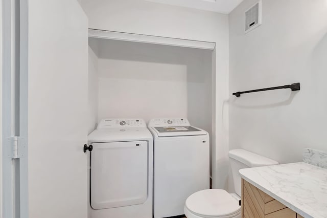 bathroom featuring vanity, toilet, and washer and dryer