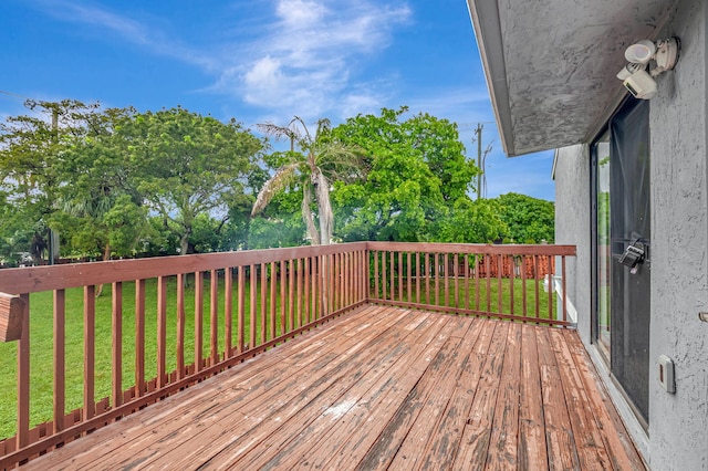 wooden terrace featuring a lawn