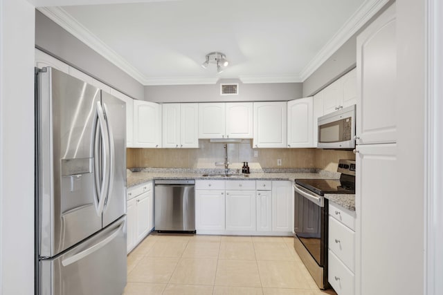 kitchen featuring white cabinets, light stone countertops, ornamental molding, and appliances with stainless steel finishes