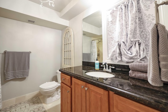 bathroom featuring tile patterned flooring, vanity, and toilet