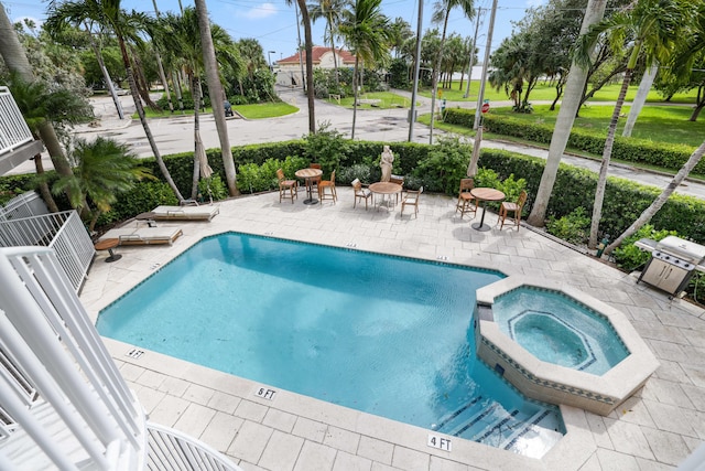 view of swimming pool with a community hot tub, a patio, and grilling area