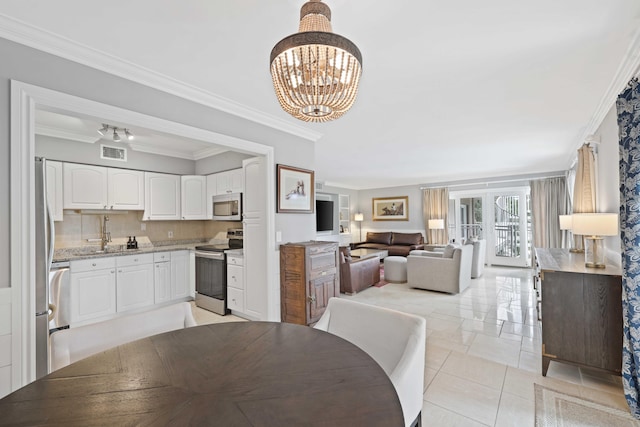 tiled dining area featuring a chandelier, crown molding, and sink