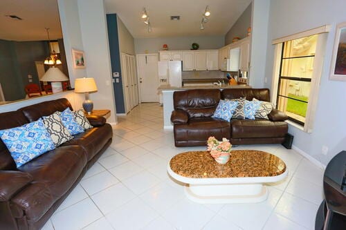 tiled living room with vaulted ceiling and an inviting chandelier