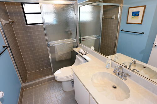 bathroom featuring vanity, an enclosed shower, and toilet