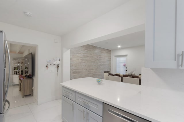 kitchen with stainless steel refrigerator, light tile patterned flooring, and tile walls