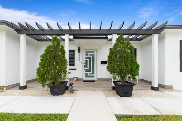 view of exterior entry with a pergola