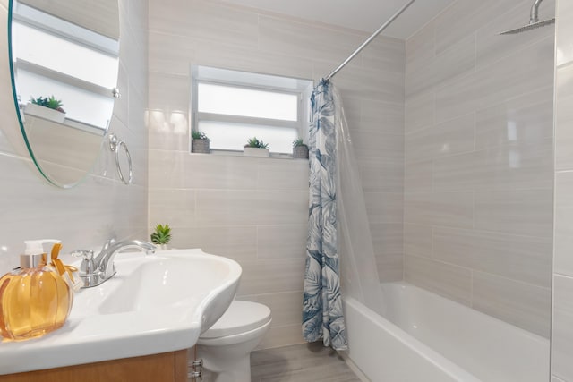 full bathroom with vanity, tile walls, toilet, and shower / bath combo