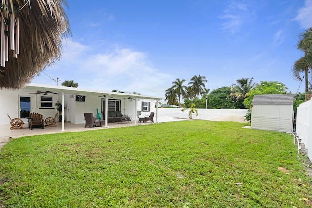 view of yard featuring a shed, a patio, and ceiling fan