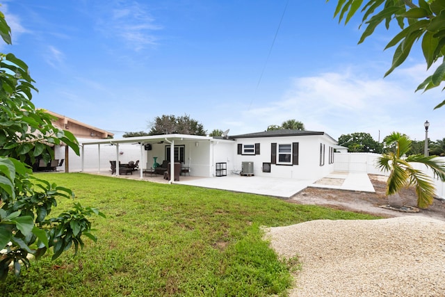 rear view of property with ceiling fan, central AC unit, a patio area, and a yard