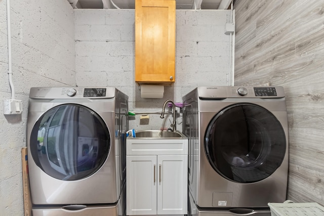 clothes washing area with cabinets, sink, and washer / dryer