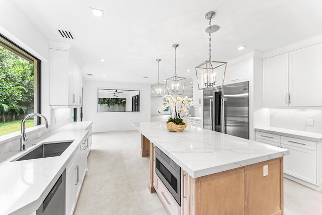 kitchen with a large island, stainless steel appliances, and white cabinets