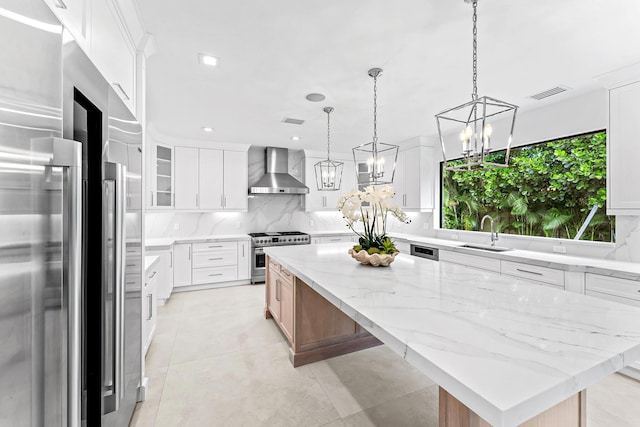 kitchen with white cabinetry, wall chimney range hood, and high end appliances