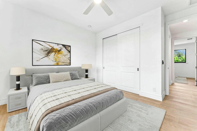 bedroom featuring ceiling fan, a closet, and light wood-type flooring