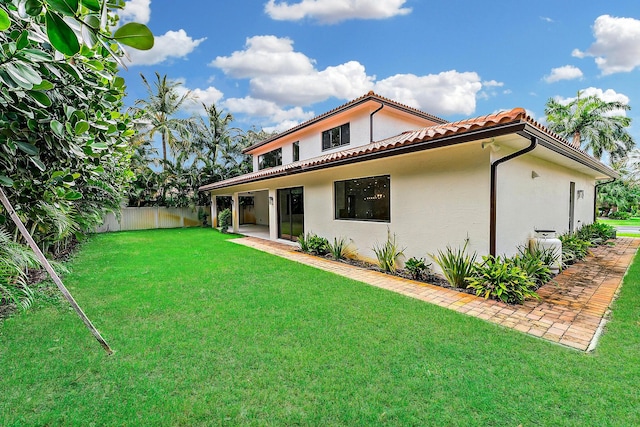 rear view of property with a patio and a yard