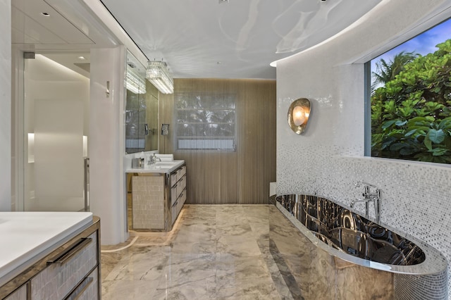 bathroom featuring vanity, backsplash, and a tub