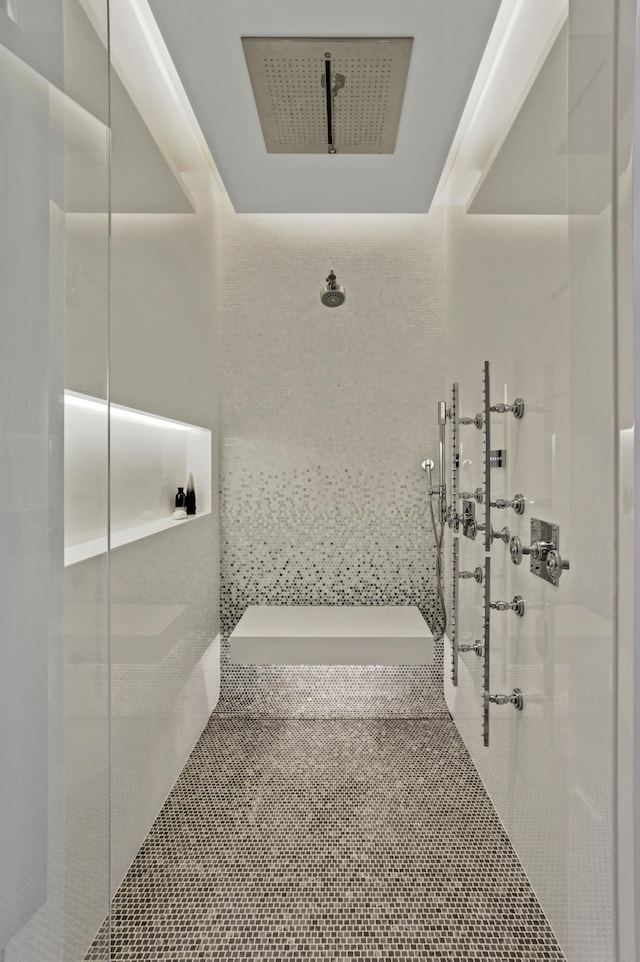 bathroom featuring tile patterned flooring and tiled shower