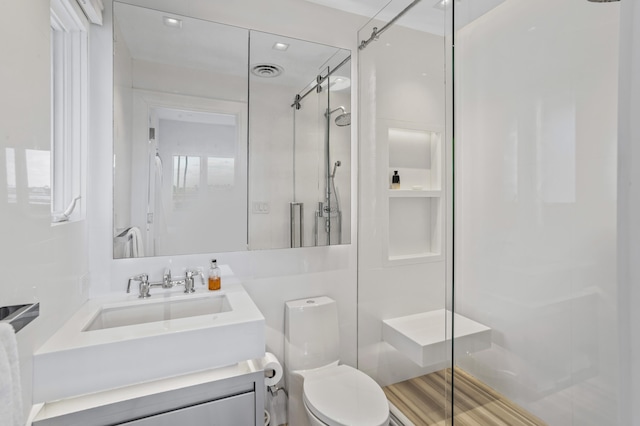 bathroom with vanity, toilet, and a shower with shower door