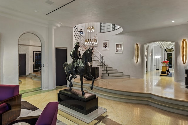 interior space featuring decorative columns, ornamental molding, and a chandelier