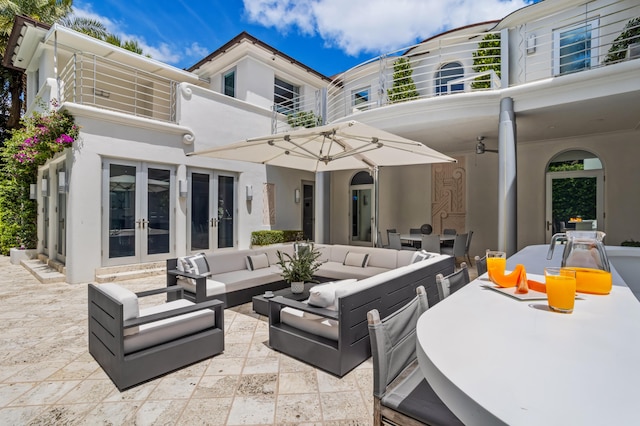 view of patio featuring outdoor lounge area, ceiling fan, a balcony, and french doors